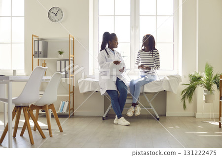 Doctor and Patient Conversing in Hospital Setting Doctor and Patient Conversing in Hospital Setting 131222475