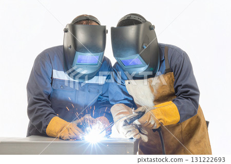 a welder worker with a protective mask while welding a welder worker with a protective mask while welding 131222693
