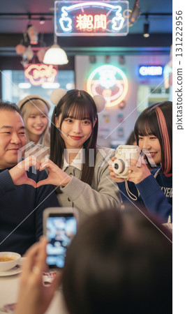 A customer taking a commemorative photo with a maid at a con cafe 131222956
