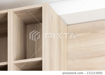 A close-up view of a light oak cabinet with open shelving 131223093