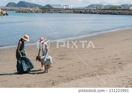 Families playing at the edge of the beach 131223991