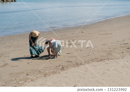 Families playing at the edge of the beach 131223992