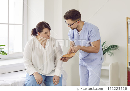 Podiatrist gives comfortable orthotic medical shoe insoles to a young overweight woman Podiatrist gives comfortable orthotic medical shoe insoles to a young overweight woman 131225516