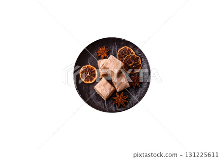 Nougat or white caramel with hazelnuts and pistachios and citrus pieces. White nougat with nuts 131225611