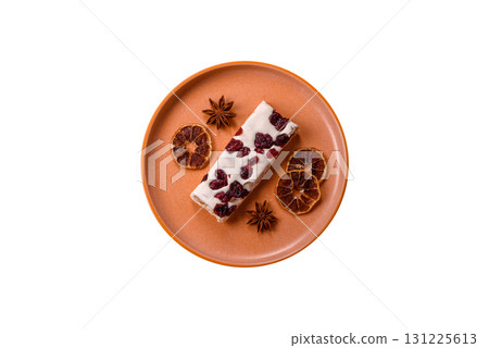 Nougat or white caramel with hazelnuts and pistachios and citrus pieces. White nougat with nuts 131225613