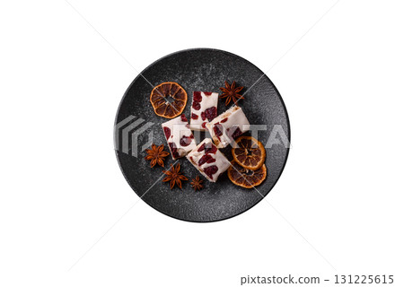 Nougat or white caramel with hazelnuts and pistachios and citrus pieces. White nougat with nuts 131225615