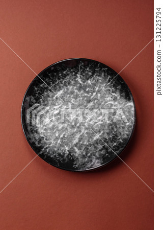 Empty round black plate for food, kitchen utensils on dining table. Empty plate 131225794