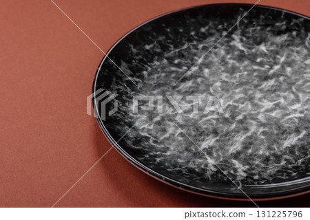 Empty round black plate for food, kitchen utensils on dining table. Empty plate 131225796
