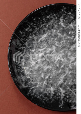 Empty round black plate for food, kitchen utensils on dining table. Empty plate 131225798