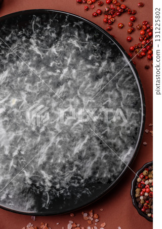 Empty round black plate for food, kitchen utensils on dining table. Empty plate Empty round black plate for food, kitchen utensils on dining table. Empty plate 131225802