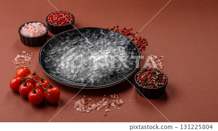 Empty round black plate for food, kitchen utensils on dining table. Empty plate 131225804