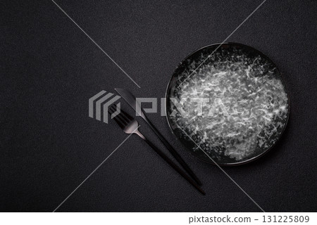 Empty round black plate for food, kitchen utensils on dining table. Empty plate Empty round black plate for food, kitchen utensils on dining table. Empty plate 131225809