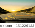 Driving on a scenic mountain road at sunset with golden sky, 131226188
