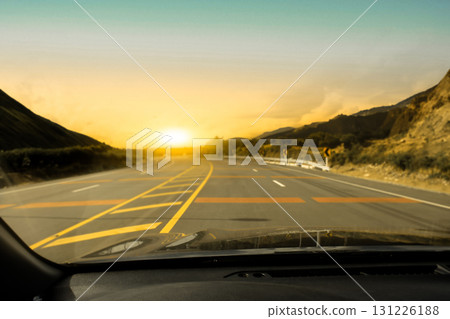 Driving on a scenic mountain road at sunset with golden sky, 131226188