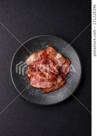 Cooked fried crispy bacon as an ingredient of a delicious English breakfast. Pieces of fried bacon Cooked fried crispy bacon as an ingredient of a delicious English breakfast. Pieces of fried bacon 131226396