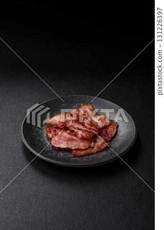 Cooked fried crispy bacon as an ingredient of a delicious English breakfast. Pieces of fried bacon Cooked fried crispy bacon as an ingredient of a delicious English breakfast. Pieces of fried bacon 131226397