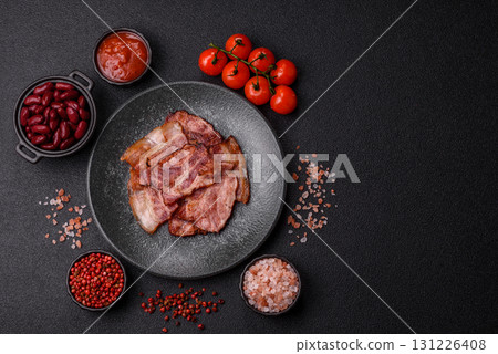 Cooked fried crispy bacon as an ingredient of a delicious English breakfast. Pieces of fried bacon 131226408