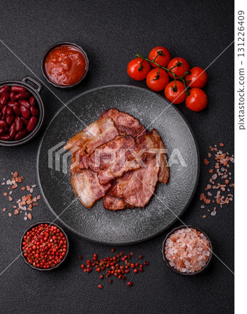 Cooked fried crispy bacon as an ingredient of a delicious English breakfast. Pieces of fried bacon 131226409