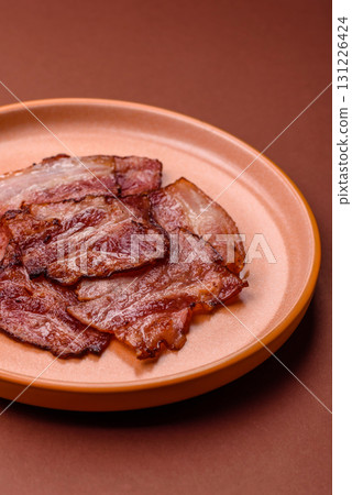 Cooked fried crispy bacon as an ingredient of a delicious English breakfast. Pieces of fried bacon Cooked fried crispy bacon as an ingredient of a delicious English breakfast. Pieces of fried bacon 131226424