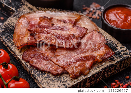 Cooked fried crispy bacon as an ingredient of a delicious English breakfast. Pieces of fried bacon 131226437