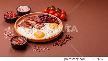 Fried egg, bacon and beans, a classic British breakfast with tomatoes. Egg, bacon and beans Fried egg, bacon and beans, a classic British breakfast with tomatoes. Egg, bacon and beans 131226475