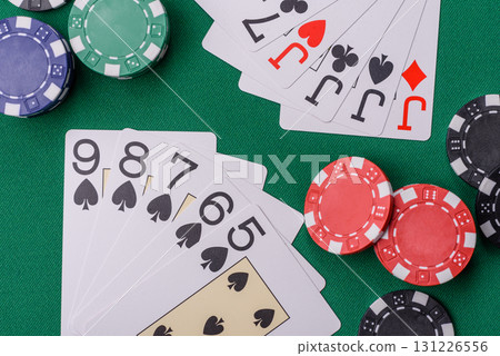 Playing card game poker in casino with chips, bets and risk. Cards and chips on elt Playing card game poker in casino with chips, bets and risk. Cards and chips on elt 131226556