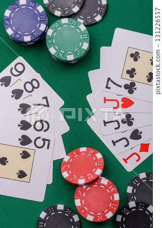 Playing card game poker in casino with chips, bets and risk. Cards and chips on elt Playing card game poker in casino with chips, bets and risk. Cards and chips on elt 131226557