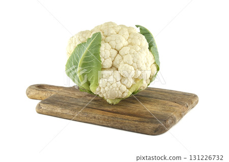Fresh cauliflower on a wooden cutting board against a white background. Fresh cauliflower on a wooden cutting board against a white background. 131226732