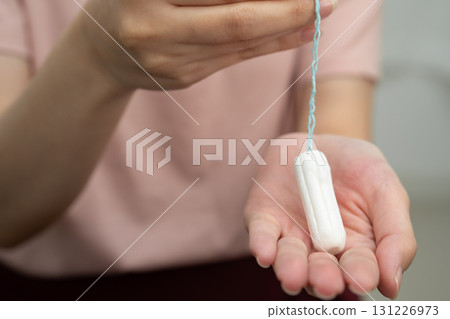 Asian woman holding cotton tampons for hygiene menstrual period cycle protection. Asian woman holding cotton tampons for hygiene menstrual period cycle protection. 131226973