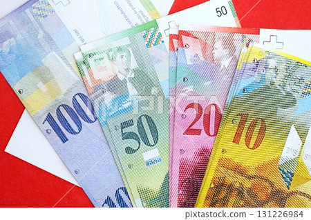 Swiss franc banknotes and flag. The current francs money bills lies on flag in big amount 131226984