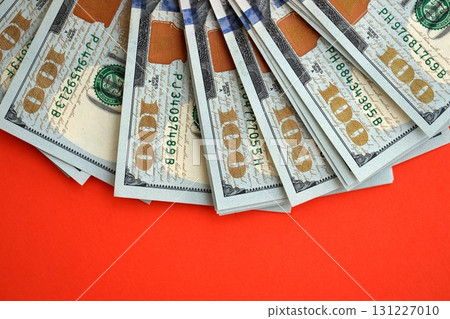 Big amount of United States hundred dollar bills on red background 131227010