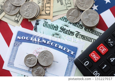 American US dollars money bills, social security number card and calculator on American flag American US dollars money bills, social security number card and calculator on American flag 131227017