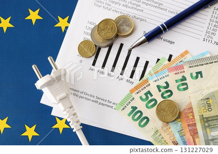 European union Euro money bills and coins with european electricity utility bill on table European union Euro money bills and coins with european electricity utility bill on table 131227029