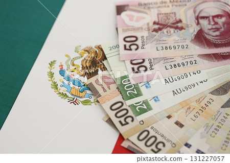 Mexican pesos money bills in big amount lies on Mexico flag close up 131227057
