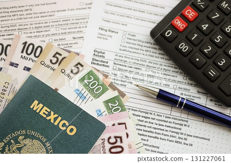 Mexican pesos money bills in big amount lies on table with pen, calculator, passport and tax forms 131227061