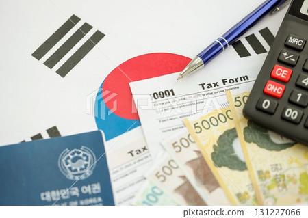 South Korean won money bills lies on table with pen, calculator, passport and tax forms 131227066