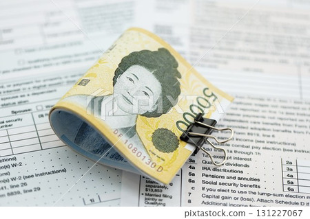 South Korean won money bills in big amount lies on table with tax forms close up South Korean won money bills in big amount lies on table with tax forms close up 131227067