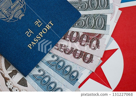 North Korean won money bills in big amount and passport lies on People Republic of Korea flag 131227068