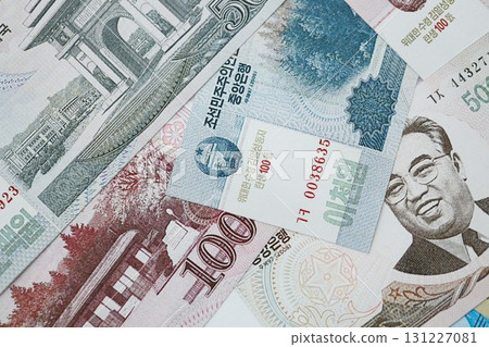 North Korean won money bills in big amount lies on white color table close up North Korean won money bills in big amount lies on white color table close up 131227081