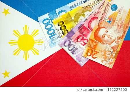 Philippines peso currency money bills lies on flag. The concept of business and investment Philippines peso currency money bills lies on flag. The concept of business and investment 131227200