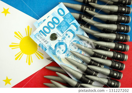 Philippines peso currency money bills and rifle bullets on flag. The concept of warfare and gun selling Philippines peso currency money bills and rifle bullets on flag. The concept of warfare and gun selling 131227202