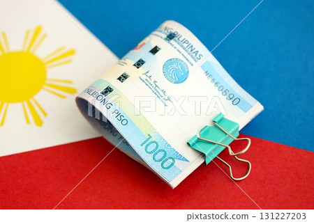 Philippines peso currency money bills lies on flag. The concept of business and investment Philippines peso currency money bills lies on flag. The concept of business and investment 131227203