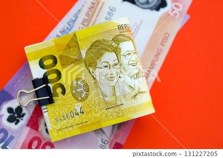 Philippines peso money bills in big amount on red. Finance and banking concept Philippines peso money bills in big amount on red. Finance and banking concept 131227205