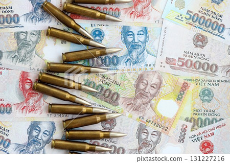 Vietnamese dong currency money bills and rifle bullets. The concept of warfare and gun selling 131227216