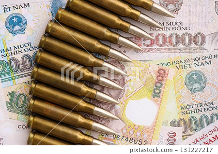 Vietnamese dong currency money bills and rifle bullets. The concept of warfare and gun selling 131227217