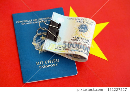 Vietnamese dong currency money bills and passport lies on flag. The concept of travel and vacation 131227227