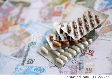 Brazilian reais banknotes and medicine pills. Brazil real money and drugs lies on table 131227236