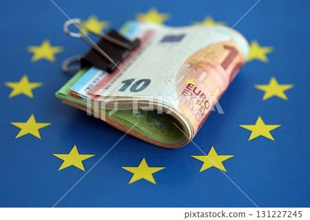 European euro currency money notes bunch on Europe union blue flag close up European euro currency money notes bunch on Europe union blue flag close up 131227245