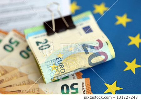 European euro currency money notes bunch on tax form and European union blue flag close up 131227248
