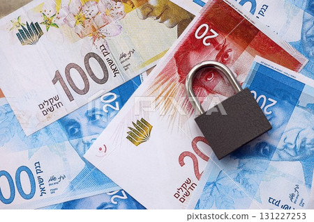 Israel New Shekels banknotes and padlock. The current Israel money bills and lock lies on table Israel New Shekels banknotes and padlock. The current Israel money bills and lock lies on table 131227253